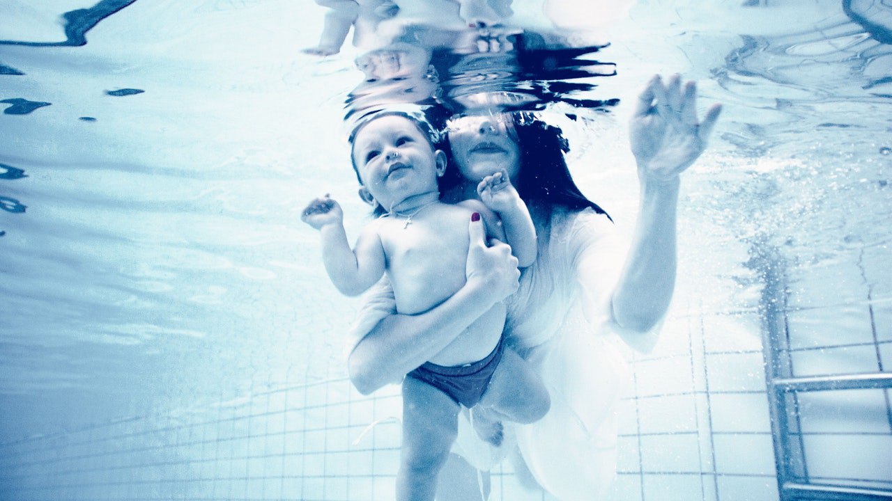 Swimming tutor with infant baby